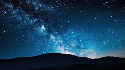   A stunning view of the star-filled night sky set against a majestic blue mountain backdrop