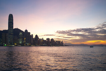 Obraz premium The Central Hong Kong skyline during sunset with purple and orange sky over Victoria Harbour