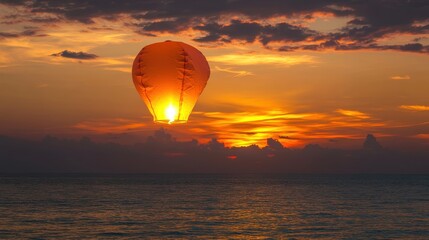 Obraz premium Serene Sunset with Floating Lantern Over Ocean