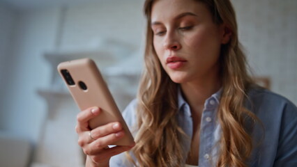 Girl scrolling news feed at smartphone kitchen closeup. Woman looking cellphone