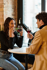 A beautiful couple shares a romantic moment, toasting with wine on Valentines Day.