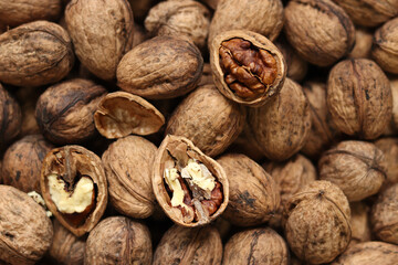 Heap of walnuts in shell, close-up, top view. Healthy eating. Harvest, agriculture. Walnuts, selective focus, background