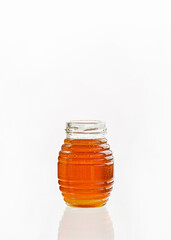 honey in a transparent jar on a white background