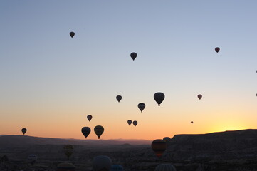 Beautiful view of hot air balloons floating in the air at sunrise with clear sky in Cappadocia, Anatolia, eastern Turkey (Türkiye)