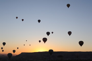 Beautiful view of hot air balloons floating in the air at sunrise with clear sky in Cappadocia, Anatolia, eastern Turkey (Türkiye)