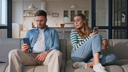 Internet addicted friends browsing smartphones domestic weekend. Offended couple