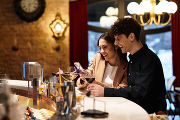 A lovely couple shares laughter and joy while celebrating their love at a restaurant bar.
