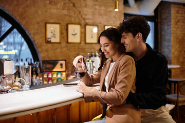 A young couple shares a loving moment, savoring their drink and celebrating love in a restaurant.