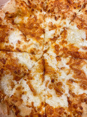 Close-up of a delicious four cheese pizza with melted cheese and a golden crust, perfect for food lovers and restaurant menus.