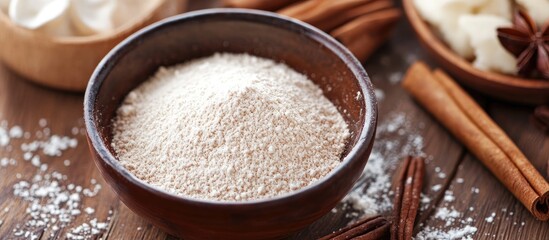 Bowl of vanilla pastry flour on wooden surface surrounded by spices ideal for baking and dessert preparation