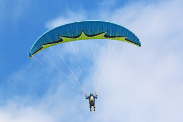 Paraglider flying in a blue sky