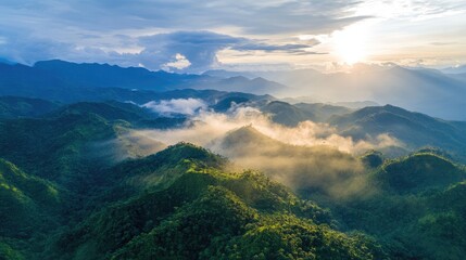 Aerial view of lush green mountains under dramatic sunset with clouds and mist creating a breathtaking natural landscape panorama