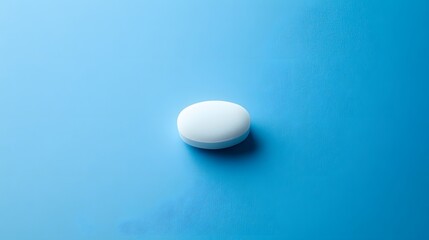 A Single White Pill Rests On A Blue Background