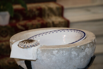 the baptismal font to proceed to the sacrament of baptism in a Catholic Church. On the edge of the...