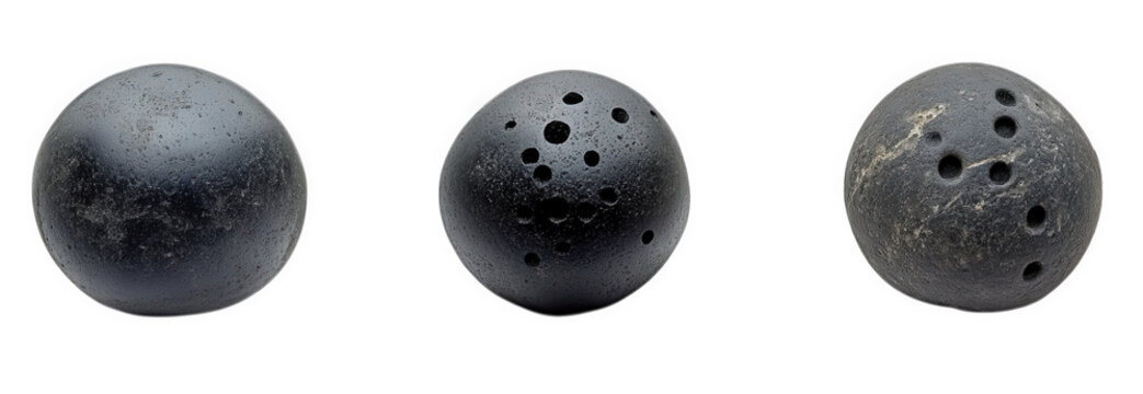 three spherical objects that appear to be bowling balls. each with varying numbers of holes they are made of a dark material and show signs of wear. suggesting they are used for recreational purposes