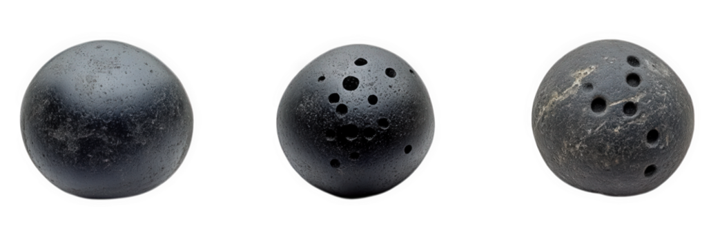 three spherical objects that appear to be bowling balls. each with varying numbers of holes they are made of a dark material and show signs of wear. suggesting they are used for recreational purposes