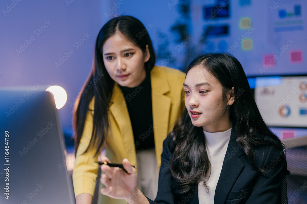 Aufkleber two young businesswomen collaborating on a computer in a modern office, discussing strategies and an