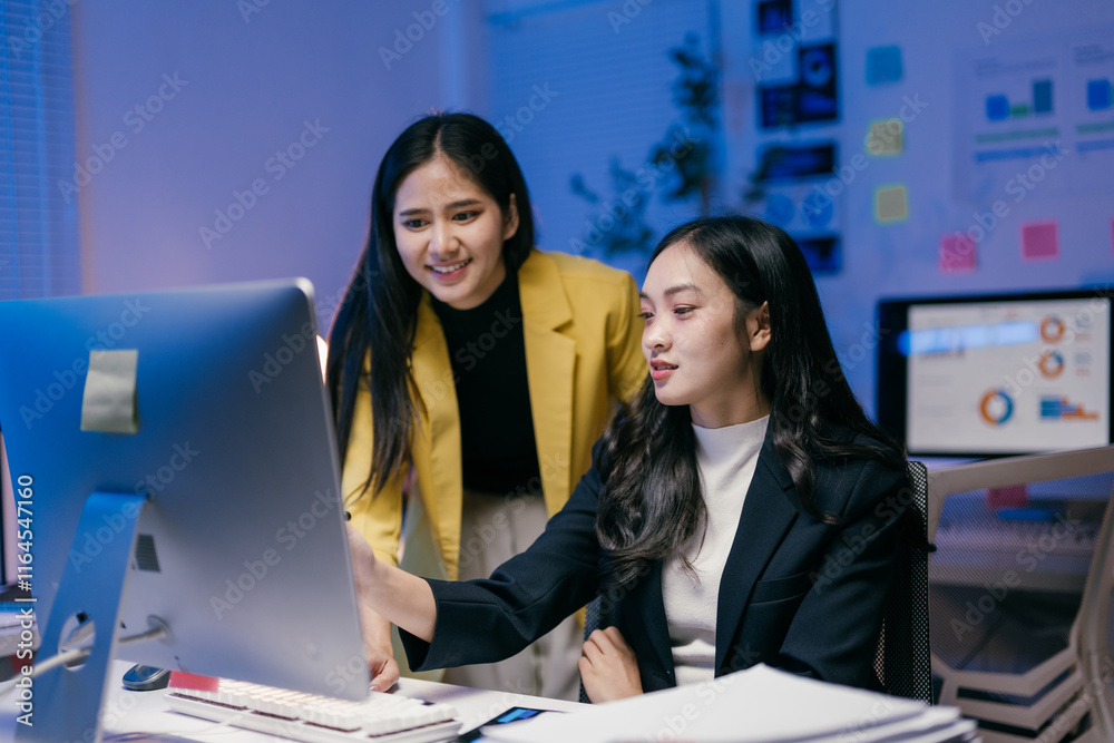 Poster two young asian businesswomen collaborating on a project, analyzing data on a desktop computer in a 