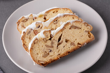 Delicious homemade stollen bread displayed on a plate with powdered sugar and chopped nuts