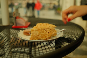 hand holding a plate of cake