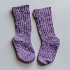 Pair of purple knitted socks on white background.