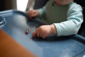 Baby developing pincer grasp picking up grape