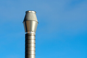 Metal chimney cap against clear blue sky in daylight