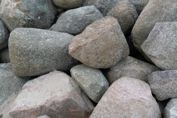 Pile of stones: A heap of natural boulders of various sizes and shapes stacked on top of each other. The overall composition of the stones looks chaotic but reflects natural harmony and strength.