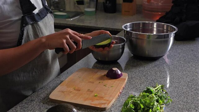 woman chopping tomato to prepare a guacamole typical of mexico avocado cubes mix