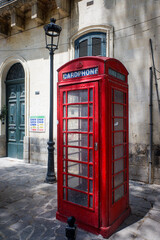 Traditional red telephone box in an historic town on the island of Malta