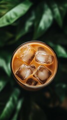 Obraz premium A glass of iced coffee with ice cubes in it. The ice cubes are scattered throughout the glass, creating a refreshing and cool appearance. Concept of relaxation and enjoyment