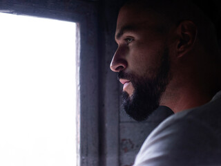 Handsome young man looking out the window