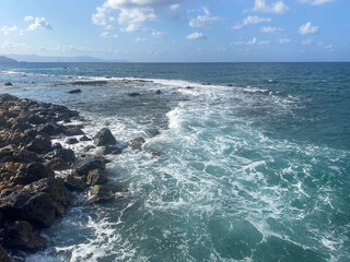 Mountains on the horizon. The ocean lapping the rocky shoreline