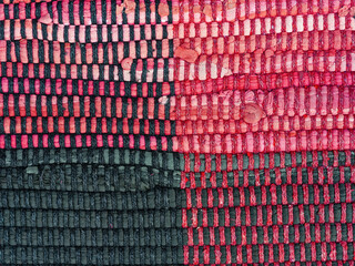 Detail of a worn woven red and black cloth rug