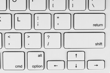 Close-up view of a white keyboard with black lettering on the keys. It could be relevant for topics related to technology, typing or computer hardware.