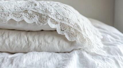 Obraz premium Stacked white pillows with delicate lace trim on a bed.