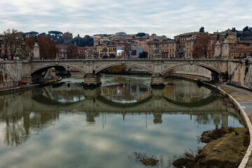 Rome Italy Scenic view of Ponte Vittorio Emanuele II with reflection on the calm Tiber River surrounded by historic architecture vibrant winter colors and details capturing Roman heritage tourism