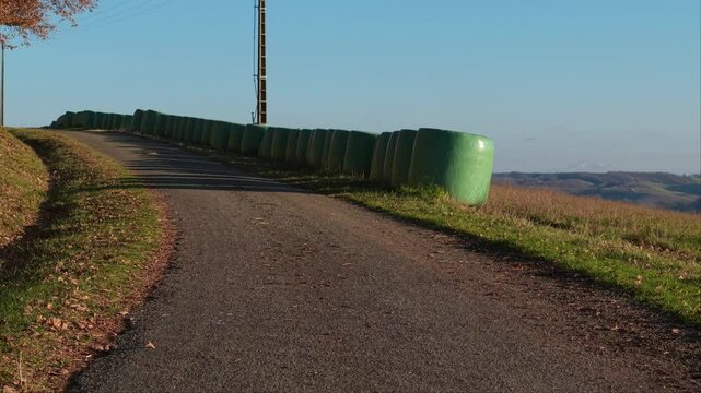 Route de campagne et bottes de paille