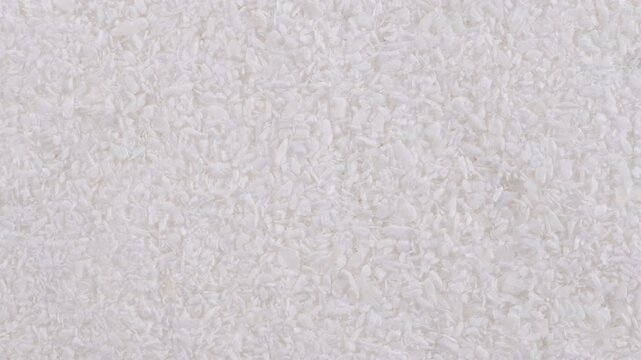 Top down view. Heap of dried shredded coconut. Macro texture of grated white coconut flakes. Slider shot. Desserts and Sweets, Tropical Flavors, Baking Ingredients concepts. 4k