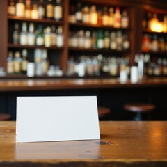 Clean white card sits atop aged wooden surface against a defocused bar setting, display, bar