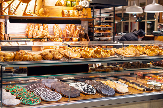 A display window case with bread, desserts, dried meats and pastries at a gourmet charcuteria and bakery in Seville, Spain.