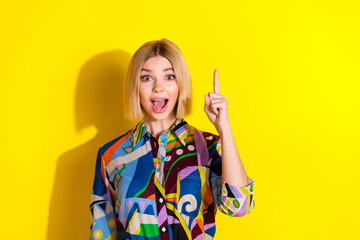 Photo portrait of pretty young girl excited point up empty space wear trendy colorful outfit isolated on yellow color background