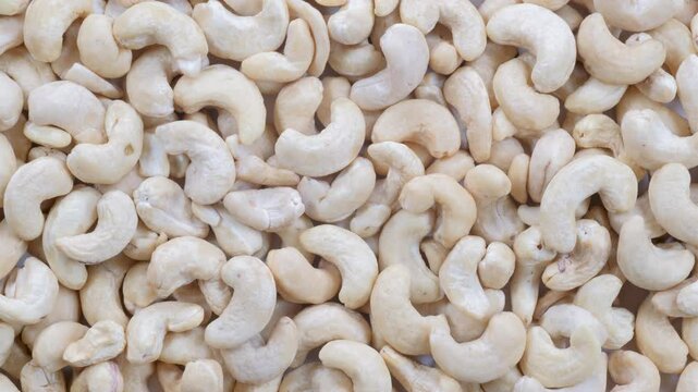 Top down view, slider shot of fresh cashew nuts in a heap. Food, nutrition, healthy eating, snacks, ingredient concepts. 4k