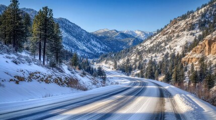 Highway cutting through snowy mountains, pine trees lining the edges 