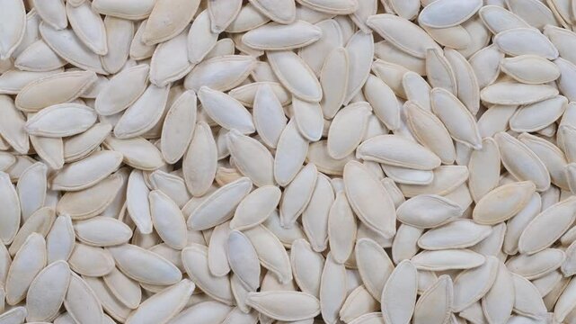 Top down view. Stack of pumpkin seeds with shell. Slider shot. Food, nutrition, healthy eating, organic, snacks, ingredient concepts. 4k