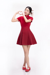 Full body portrait of joyful beauty Asian woman in red Cheongsam Chinese traditional dress celebrating and making heart shape hand sign isolated on white background.