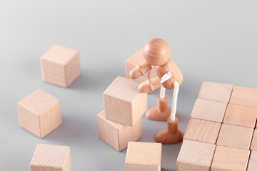 A wooden man carrying blocks