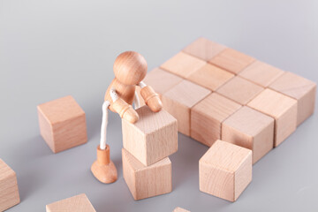 A wooden man carrying blocks
