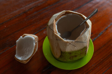 Es kelapa jeruk, an indonesian traditional refreshment drink, made with squeezed orange juice and coconut water and grated coconut flesh, served on whole coconut fruit