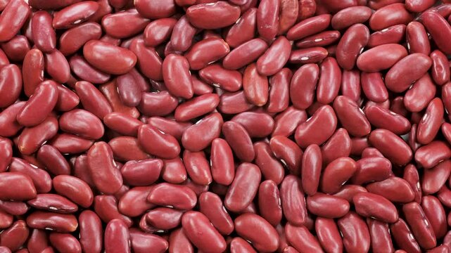 Top down view. Heap of dried uncooked red kidney beans, (Mexican beens) slider shot. Cooking, legumes, healthy eating, food preparation concepts. 4k